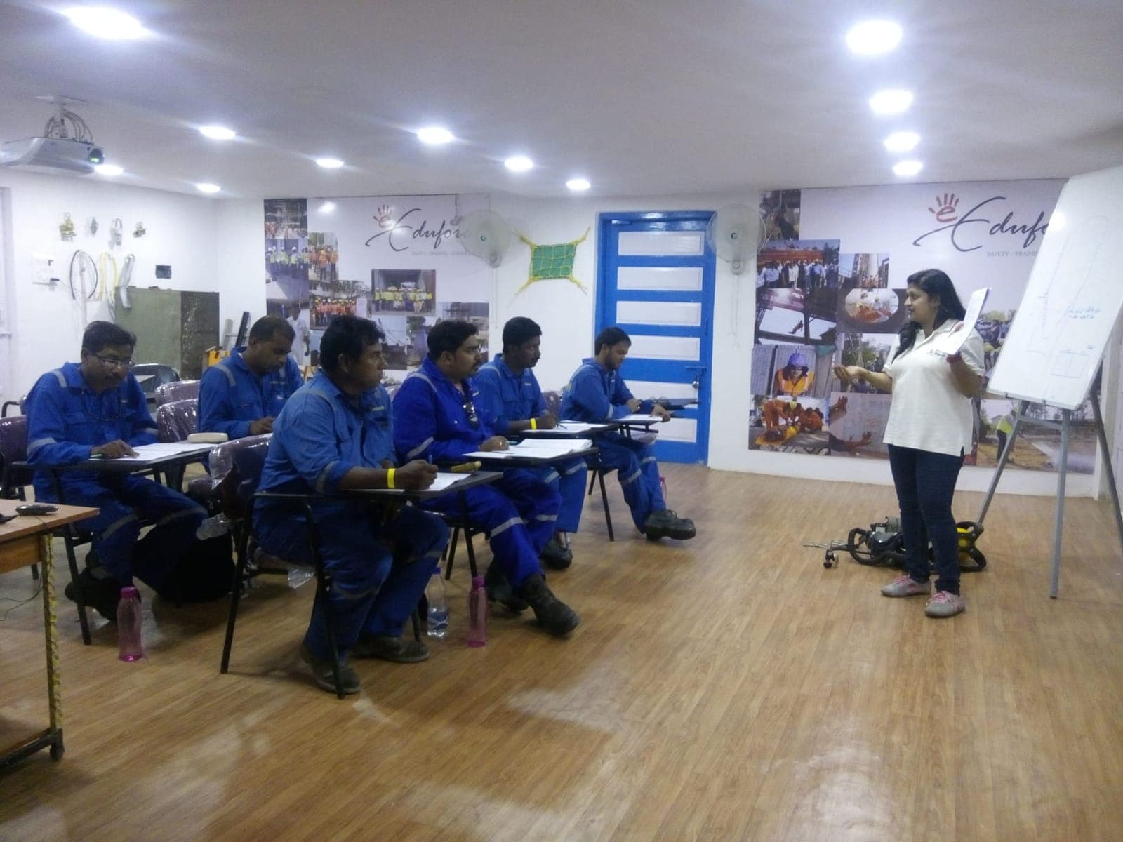 Participants seated at tables during a classroom safety session with the trainer at the front