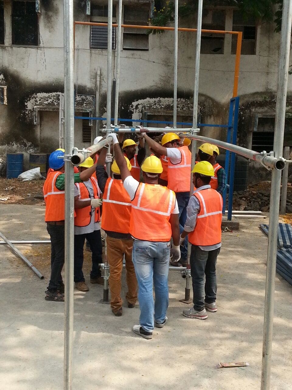 Trainees erecting a tube-and-coupler scaffold during a practical scaffolding session