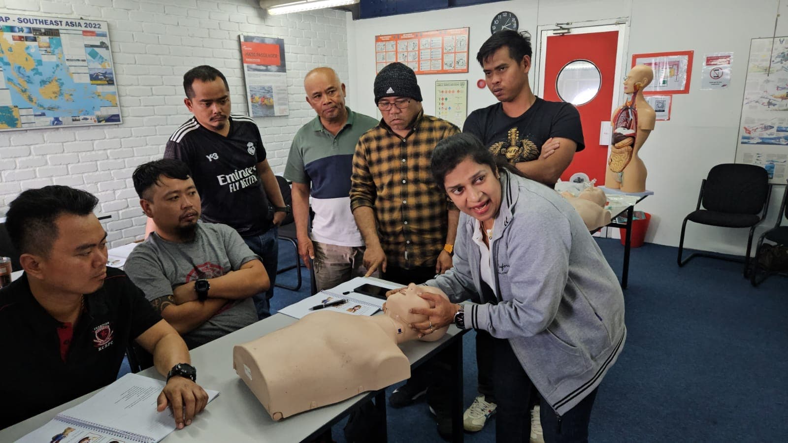 Eduforce trainer coaching an international group on airway management with a training manikin during GWO Enhanced First Aid