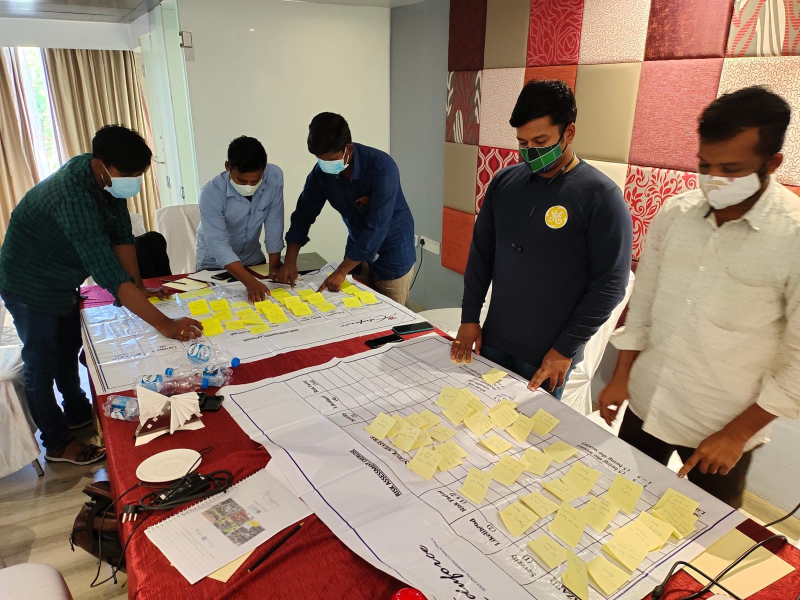 Participants completing a risk assessment matrix with sticky notes during a workshop