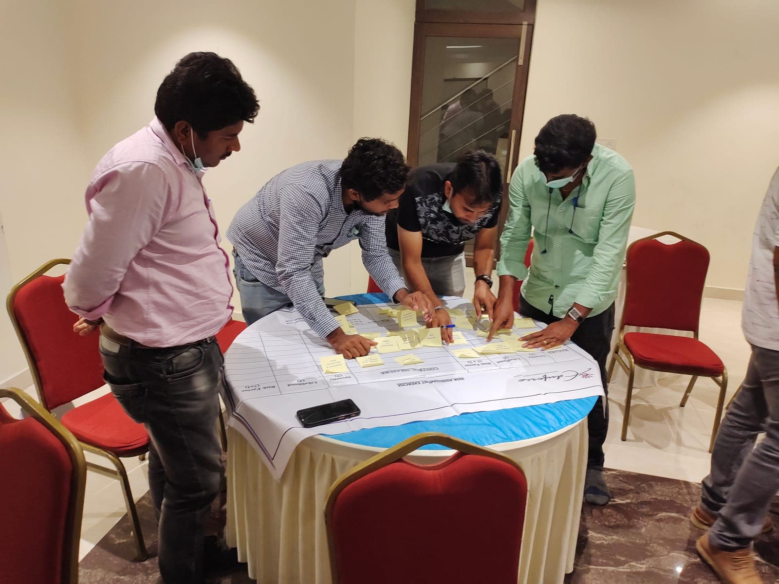 Participants working together on a group exercise around a table during a training workshop
