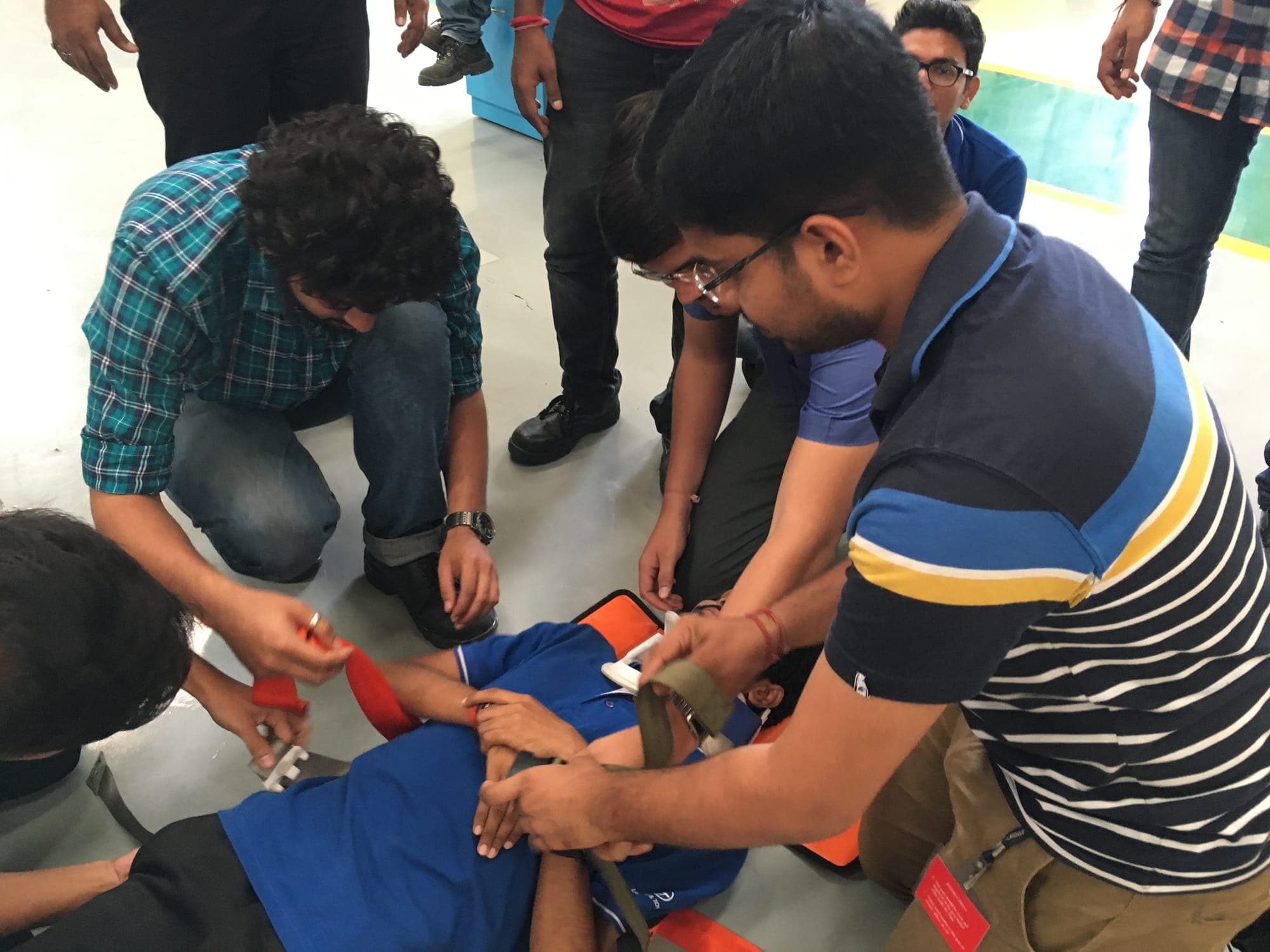 Participants securing a volunteer casualty into a rescue stretcher during practical training