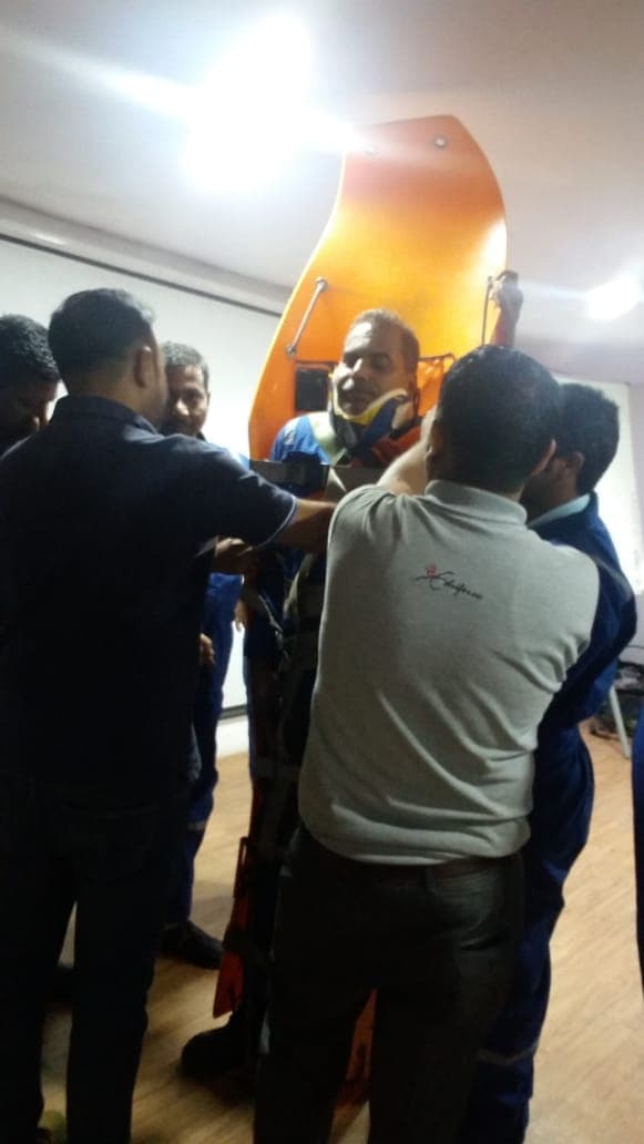 Group lifting a casualty in a basket stretcher during an emergency response drill
