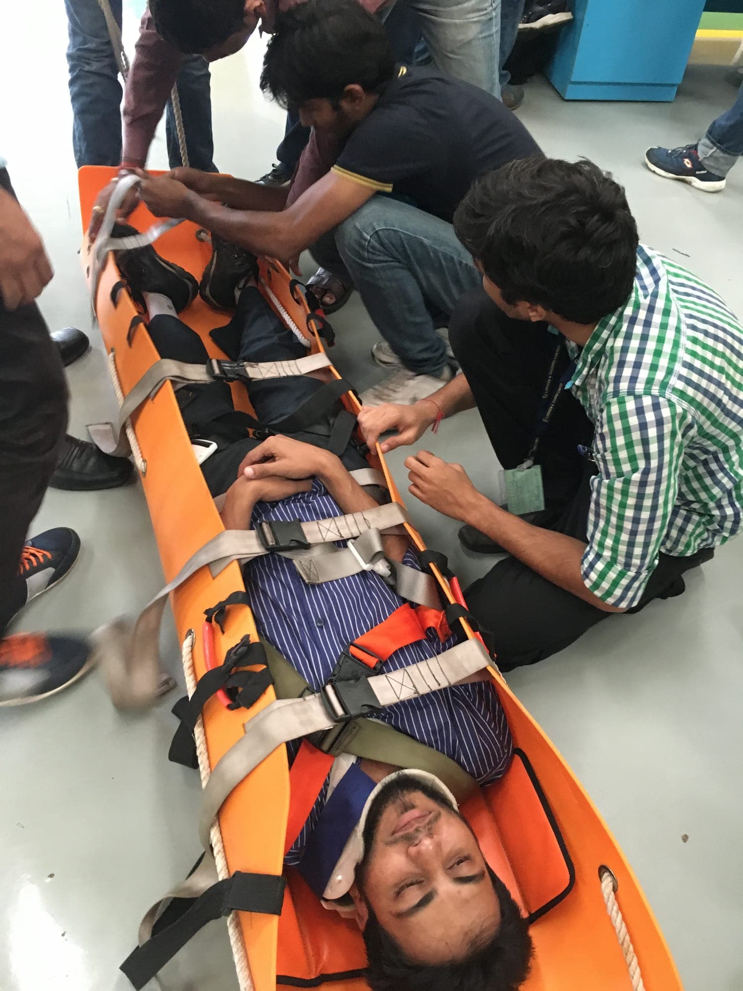 Casualty secured on an orange rescue stretcher during a casualty handling exercise