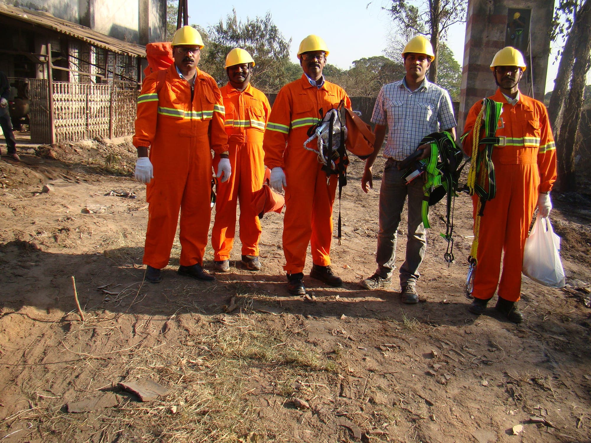 Confined space rescue team assembled outdoors with harnesses, lines and rescue equipment