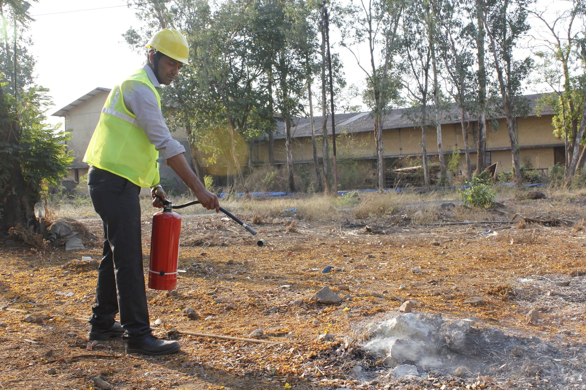Trainee approaching a training fire with a carbon dioxide extinguisher during a practical exercise