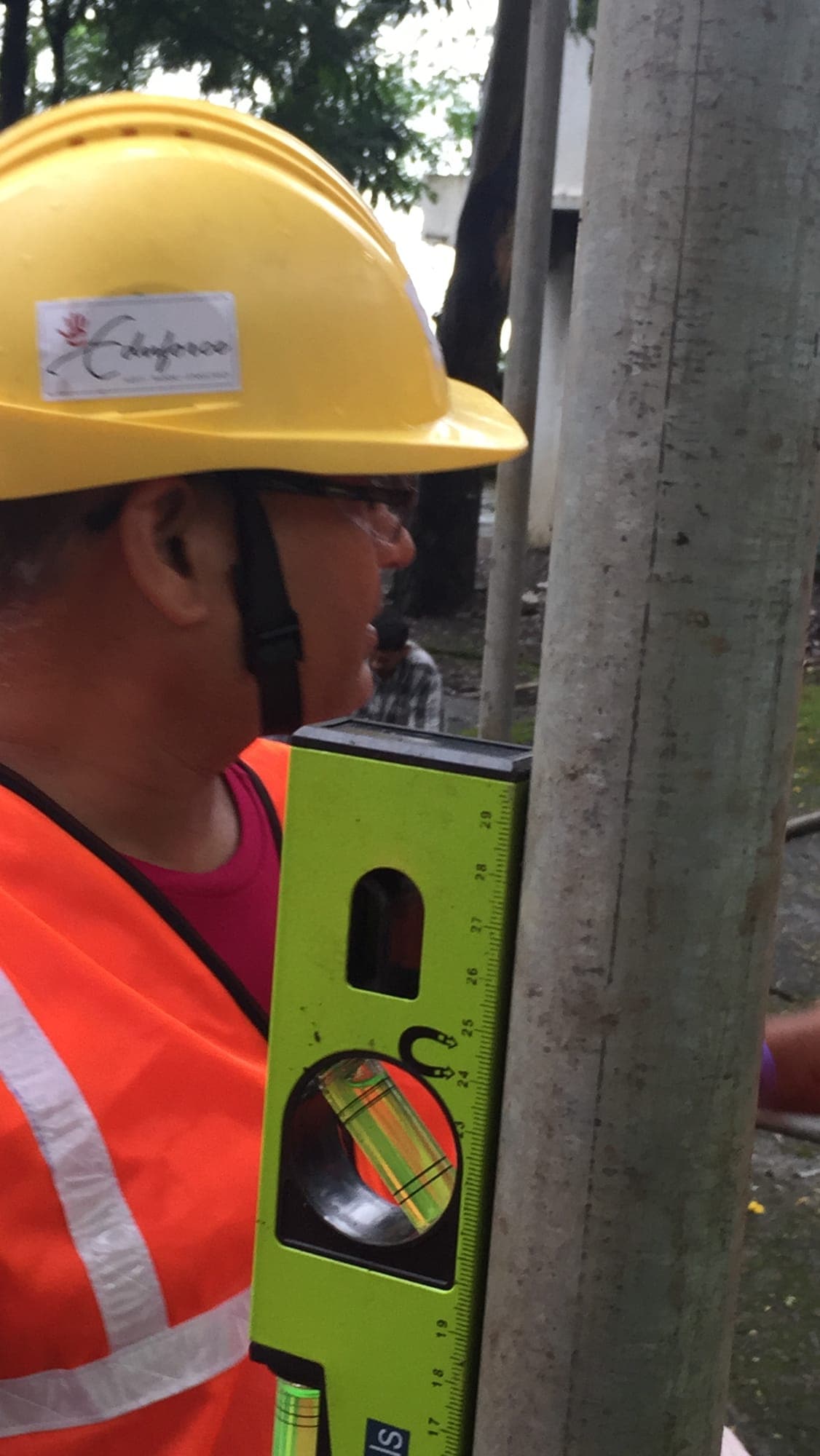 Participant using a spirit level to check a scaffold tube during a scaffolding exercise
