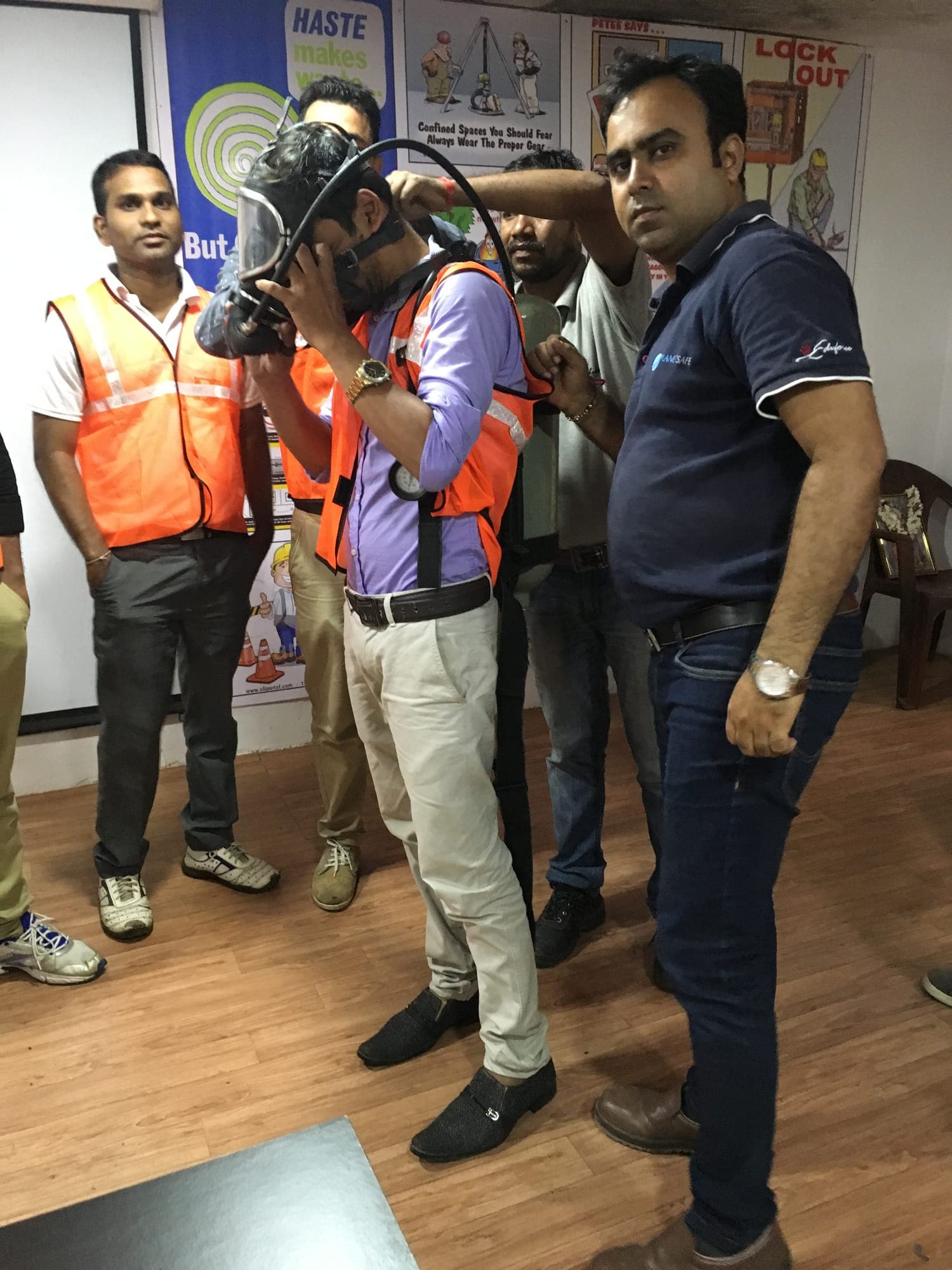Participant donning a self-contained breathing apparatus set under instructor supervision