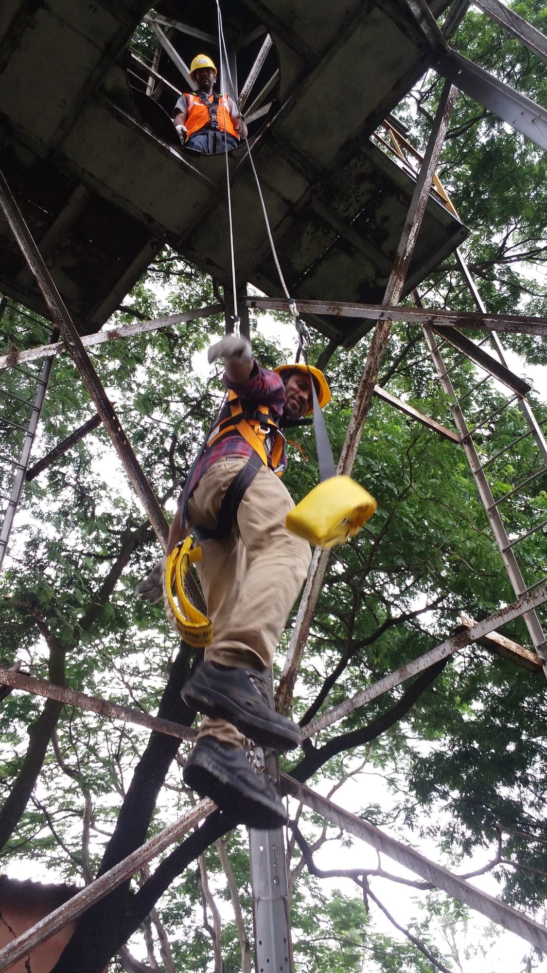 Participant performing a controlled descent from a steel structure during self-evacuation training