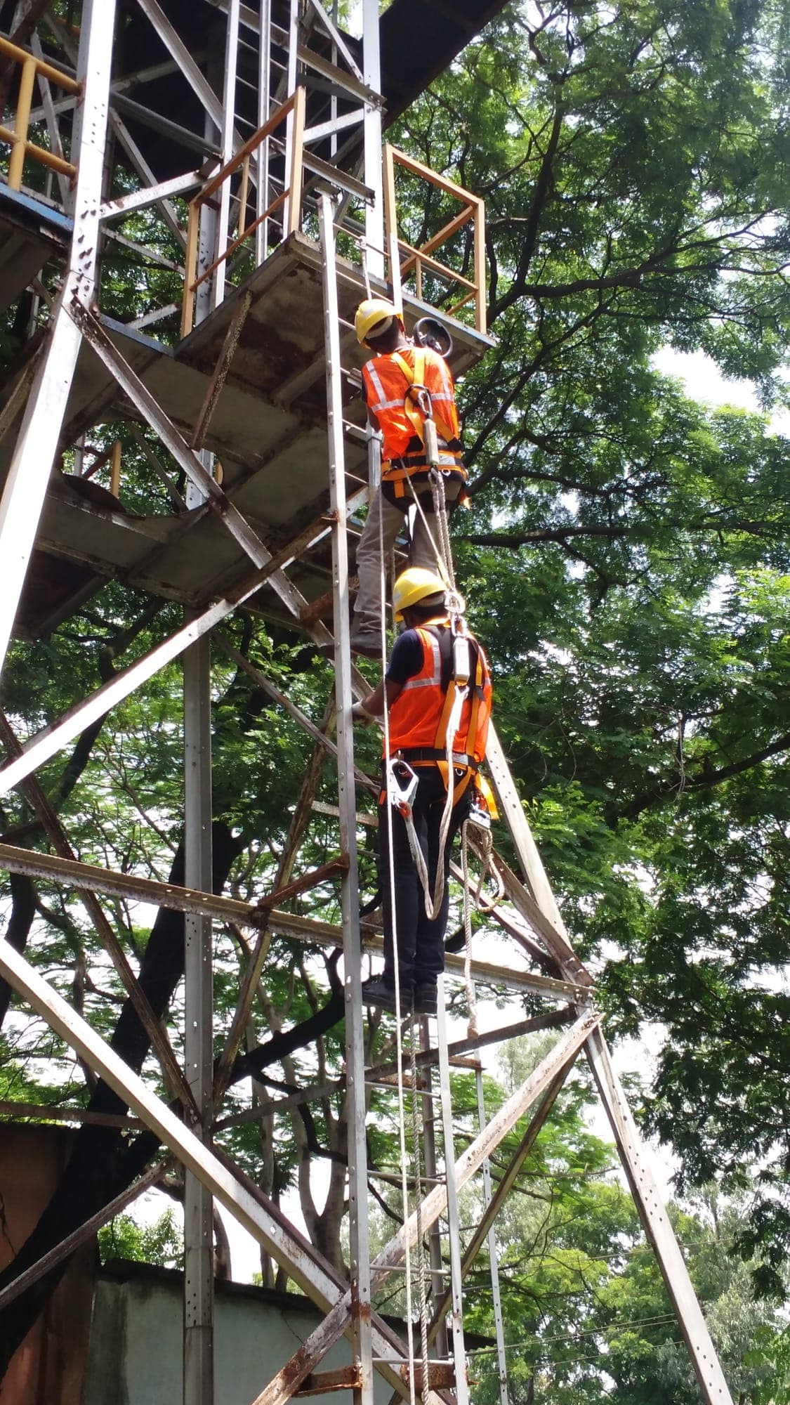 Trainee positioned high on a steel tower during a work at height practical exercise