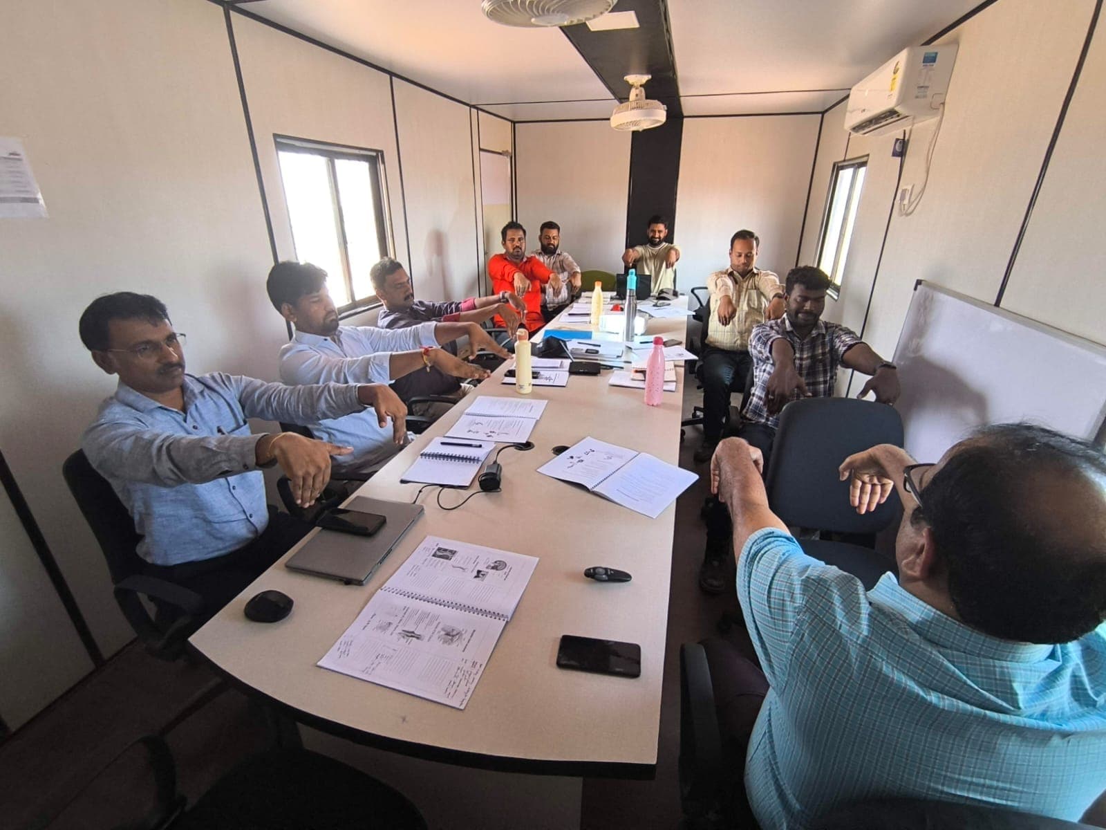 Participants stretching their arms at their desks during a training session