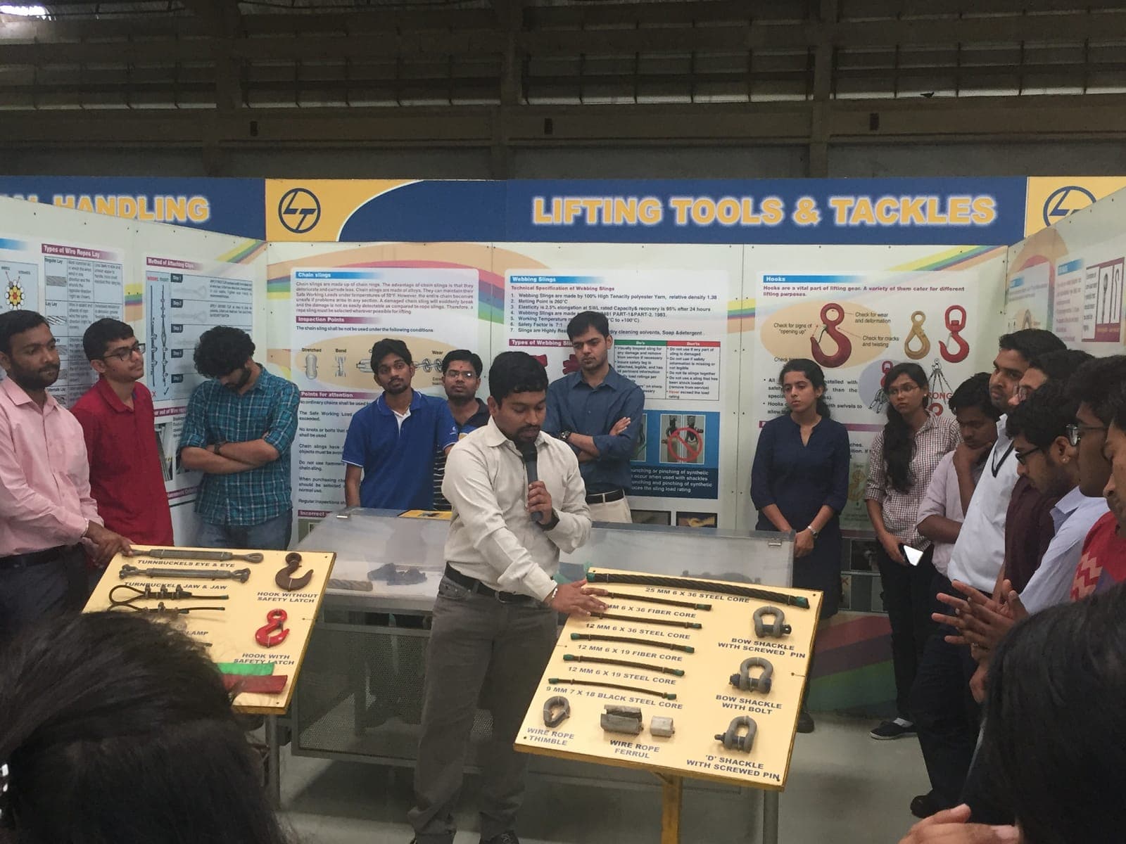 Trainer explaining wire rope slings, shackles and hooks on a lifting tools display board