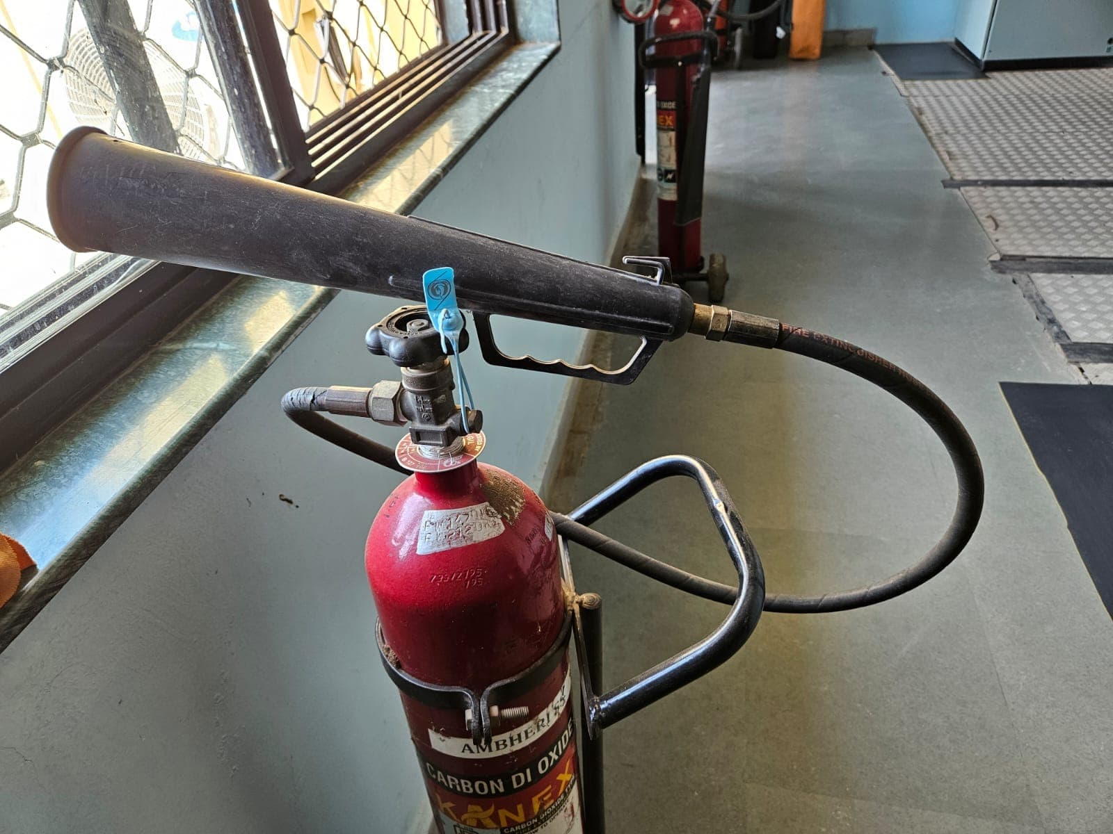 Carbon dioxide fire extinguisher mounted in a building corridor