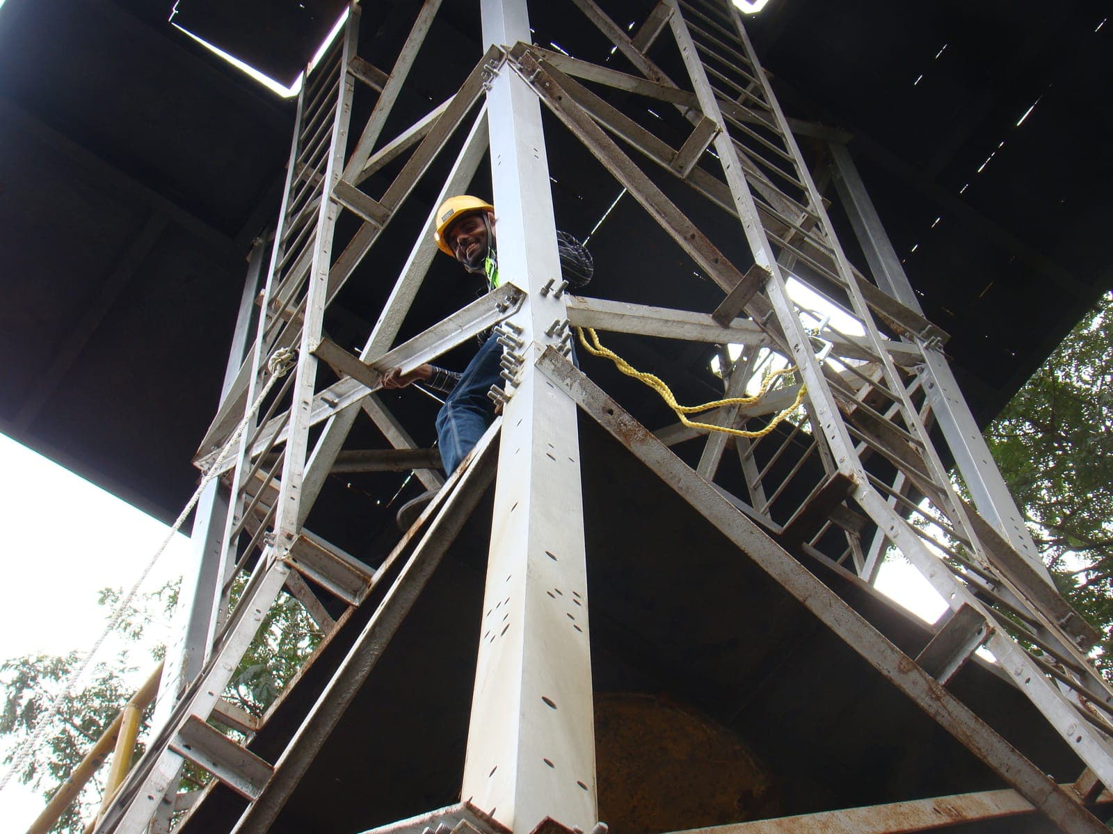 Trainee in a hard hat and harness climbing inside the steel training tower at the Eduforce training centre